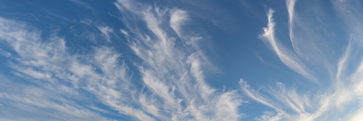 peaceful blue sky with white cirrus clouds. serene cloudscape. widescreen panoramic photo of large size in 15x5 format