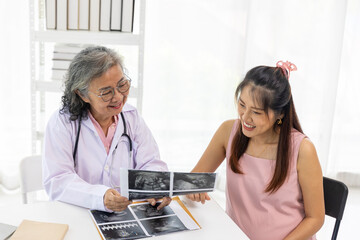 Senior female Doctor Discussing Ultrasound Results with Pregnant Woman