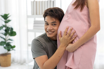 Loving Husband Embracing Pregnant Wife listening sound of heart his baby