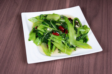 Stir-fried vegetable lettuce tips on a white plate