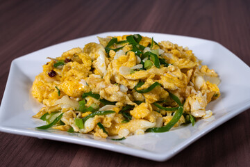 Scrambled eggs with green pepper on a white plate