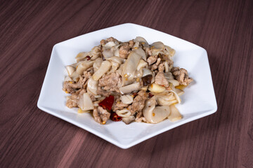 Sauteed pork with pleurotus eryngii on a white plate