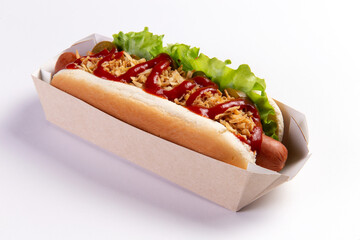 Appetizing hot dog in packaging on a light background.