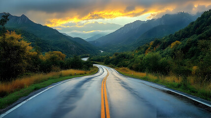 Fototapeta premium Wet Asphalt Road Winds Through Mountain Valley at Sunset after Rainfall