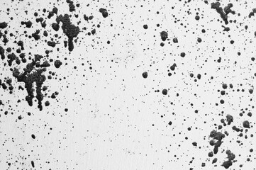 gray background, photograph of black paint splashes on white wall