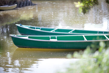 Pair of green canoes moored on a lake in Thailand