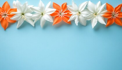 Floral Frame of Orange and White Flowers on Soft Blue Background, Copy Space for Text.