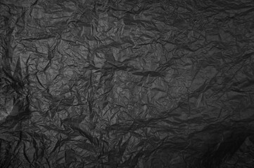 Fototapeta premium Plastikfolie in schwarz als zerknitterter Hintergrund