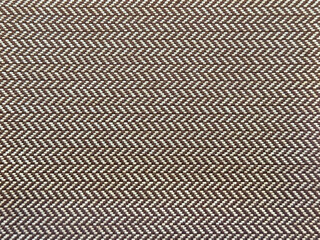 Fototapeta premium Close up of upholstery fabric in chevron pattern, in brown color. Inverted v shape chevron pattern seamless background texture.