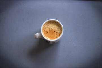 Cup with aromatic coffee on a gray background 