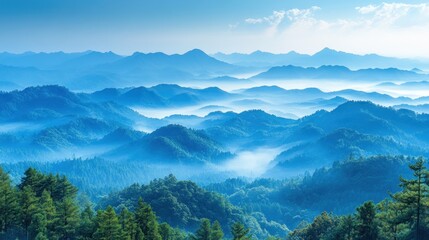 Obraz premium Serene mountain landscape with misty valleys and distant peaks under a blue sky.
