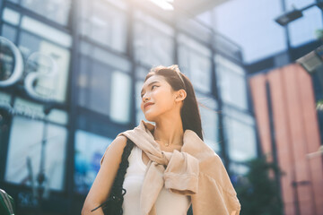 Youth asian woman looking up at outdoor urban teenager gen z lifestyles