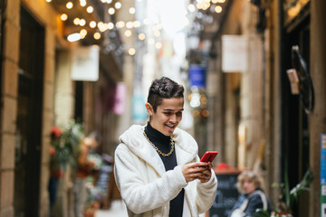 Young man using smartphone in city center during christmas time