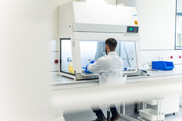 Scientist working with sterile cabinet in laboratory performing experiment