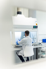 Scientist working with samples in a fume hood in modern laboratory