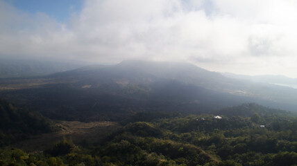 Morning View of Mount Batur Kintamani with Lush Green Forests and Misty Clouds Overlooking the Scenic Landscape in Bali Indonesia