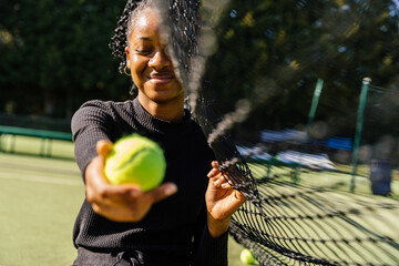 Woman holding tennis ball on outdoor tennis court - Powered by Adobe