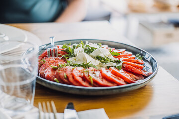 Fresh tomato salad with arugula and fennel on a rustic plate, showcasing vibrant farm-to-table dining and organic simplicity