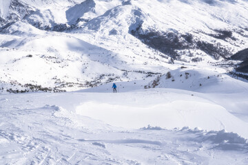 Obraz premium A solitary skier, immersed in the serene beauty of snowcovered mountains, skillfully navigates the terrain, surrounded by breathtaking scenery and majestic peaks, Montgenevre ski village, Alps, France