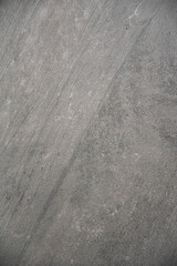 Stone texture with natural diagonal striations and muted gray tones.