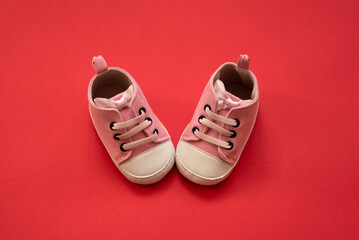 Close-up, on a red background, children's shoes for a girl.