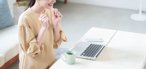 家でパソコンで仕事する女性