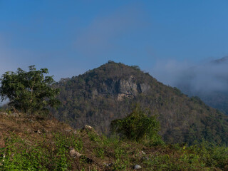 Aerial view of mountains in low clouds at sunrise in summer.