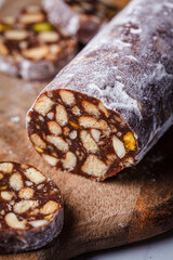 Chocolate salami with nuts on board. Traditional Italian sweet sausage for Easter.