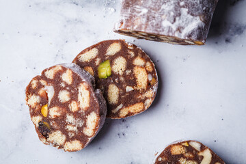 Chocolate salami with nuts on white background. Traditional Italian sweet sausage for Easter.