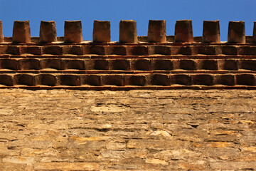 Ancient terracotta roof tiles at the cornice of the château comtal castle in the old town of Carcassonne, France