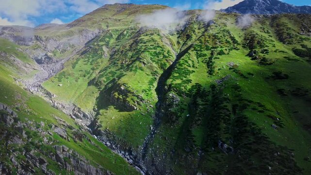 Beautiful drone shot of the lush green Himalayan moutains during monsoon season in Himachal Pradesh, India