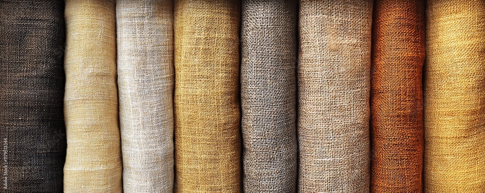 Poster rolls of linen fabric showing a range of colors from dark brown to light gold