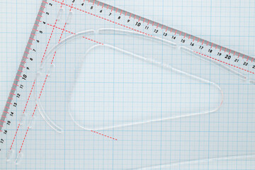 One sheet of graph paper with a plastic ruler, macro, top view.