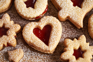 Heart and star shaped Linzer Christmas cookies filled with strawberry marmalade and dusted with sugar