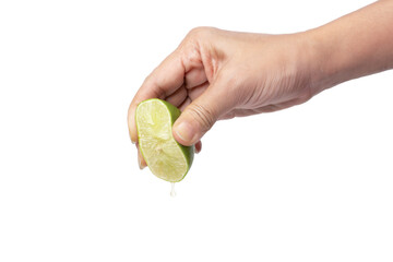 Hand squeeze lime with lime juice dripping on white