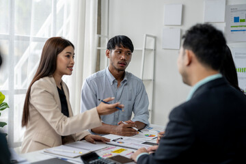 A group of people are sitting around a table, discussing something