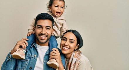 Joyful family portrait of young hispanic parents and child for lifestyle and family happiness themes