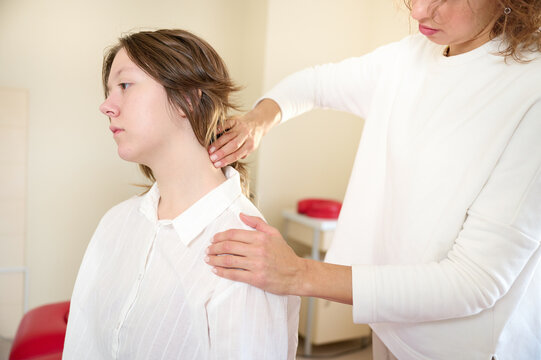 Physical therapist doing chiropractic adjustment on shoulder of patient in treatment office room. Osteopathic medicine and physiotherapy concept. Crop view