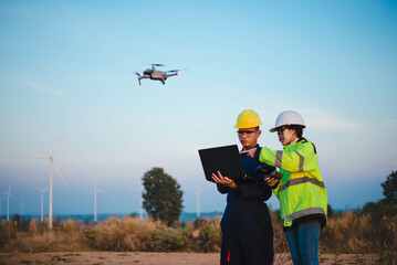 Engineer and technician is flying drones to inspect wind turbine installation sites to produce enough renewable energy.