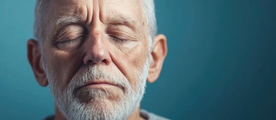 World Alzheimer's Day Concept with Senior Caucasian Man's Serene Face and Closed Eyes against Soft Blue Background for Awareness and Celebratory Themes