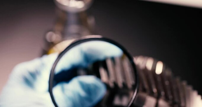 Close-up of a mechanical gear being inspected with precision tools for quality at an industrial facility.