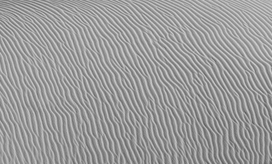 The wavy sandy surface of the dune. Closeup of sand pattern