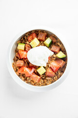 A delicious bowl of hearty grain topped with diced tomatoes, zucchini, and a perfectly poached egg. Ideal for a healthy breakfast or lunch option. Fresh and nutritious meal.