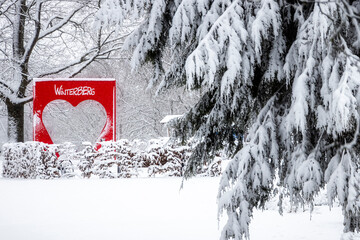 rotes Herz mit Schriftzug im verschneiten Park