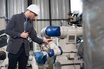 Business or engineer Caucasian male checking robot arm	