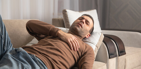Fototapeta premium Caucasian man having heart attack at home.