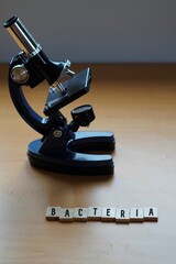 BACTERIA concept, research. wooden letters with a microscope on the table