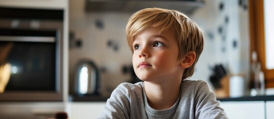 Child engaged in online learning in a modern kitchen thoughtful expression with space for educational content or text overlay
