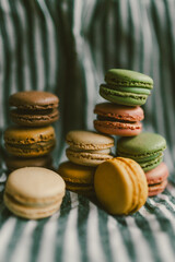 A pile of colorful macarons on a stripped background