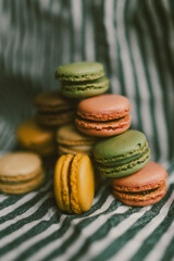 A pile of colorful macarons on a stripped background